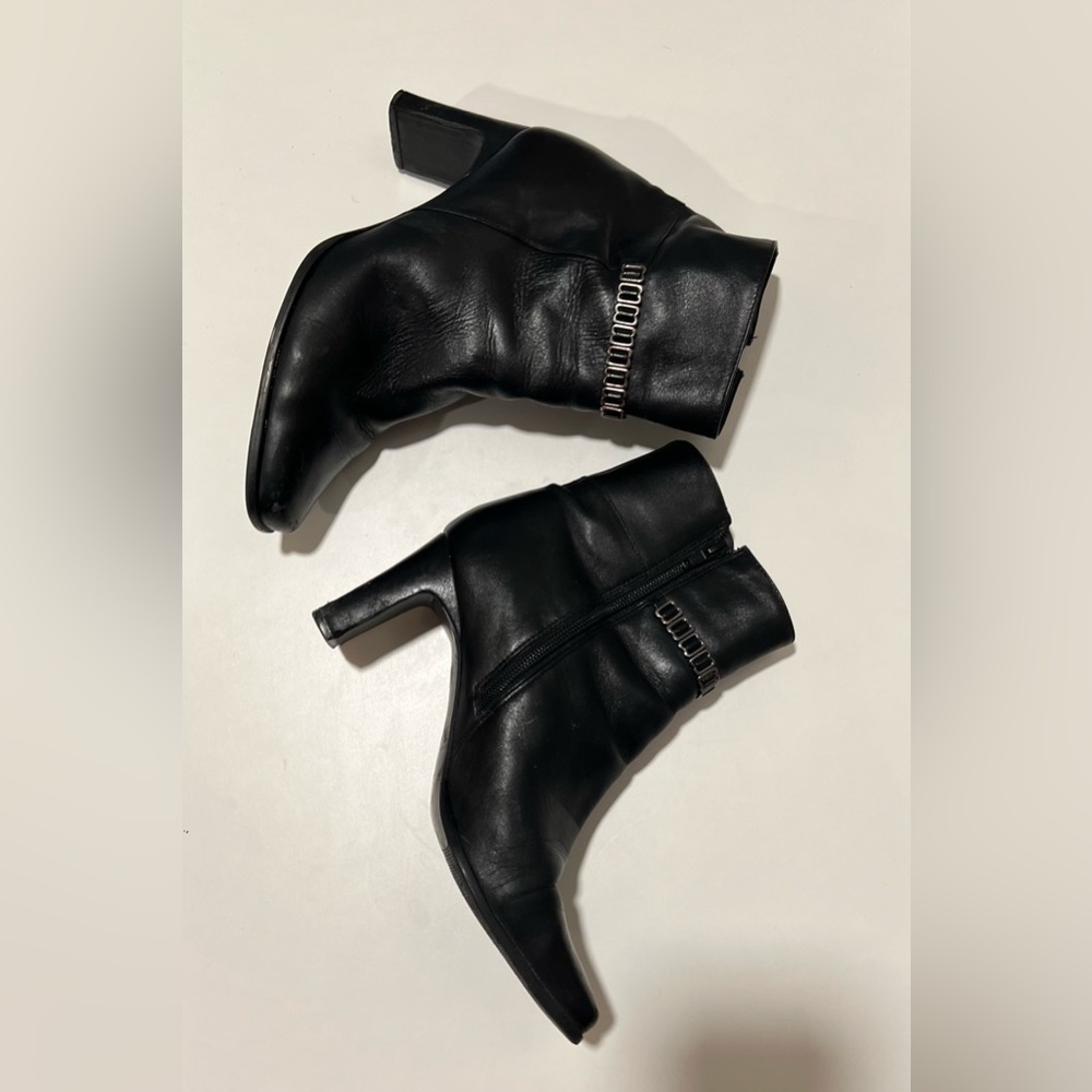 Markon black leather booties with heels, zipper and striking accents.